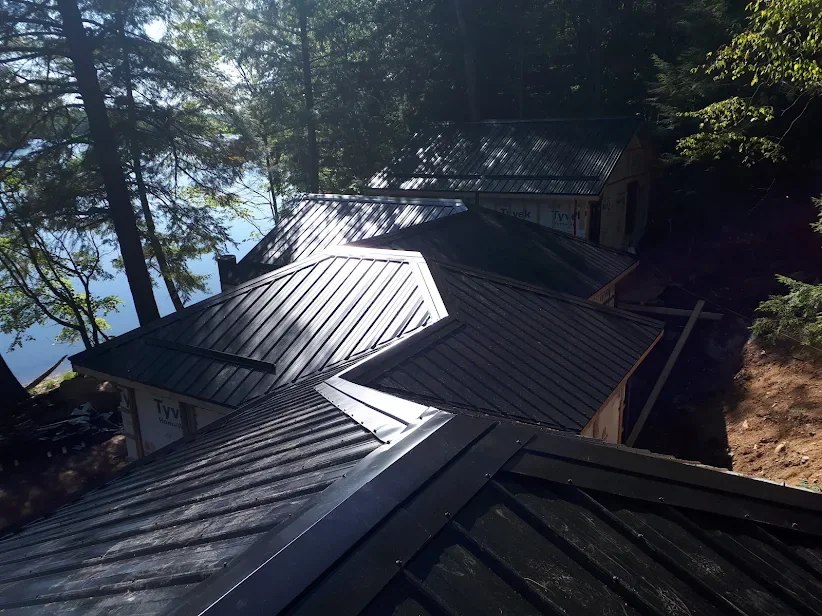 Upper roof view of dark standing seam steel on a lakefront building.