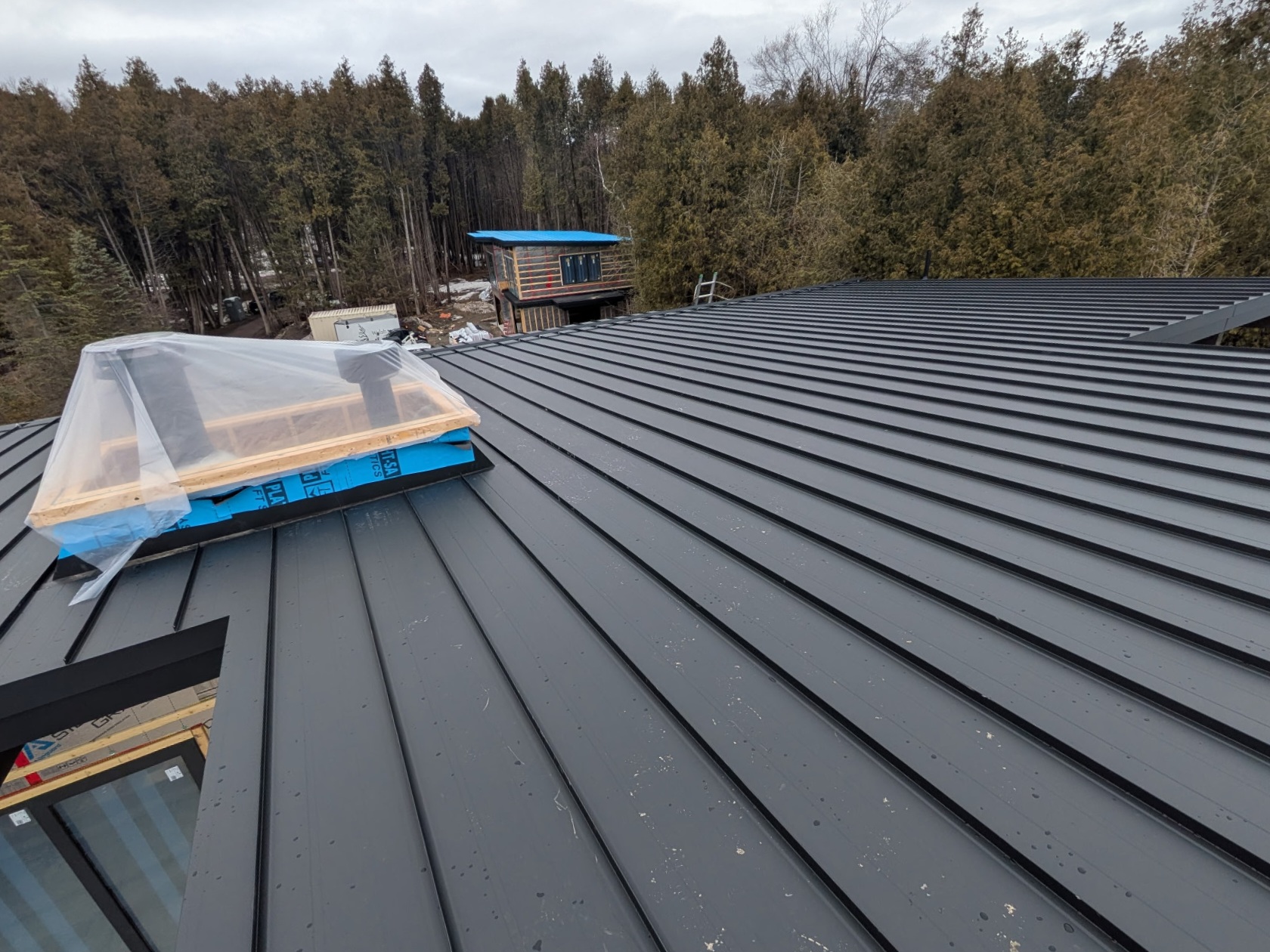 Standing seam roof detail around a skylight.