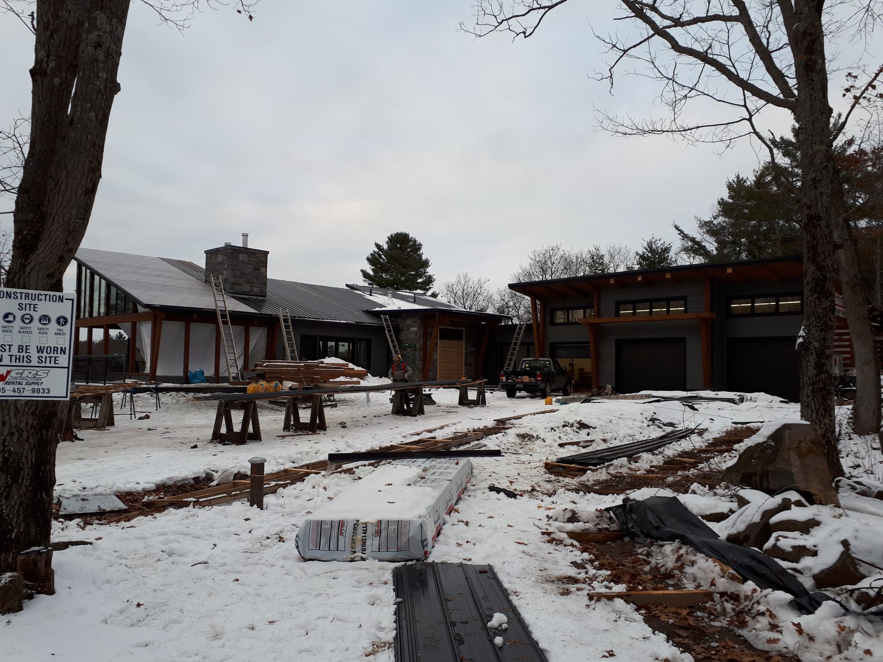 Modern Kawartha-area property with a dark steel roof in winter.